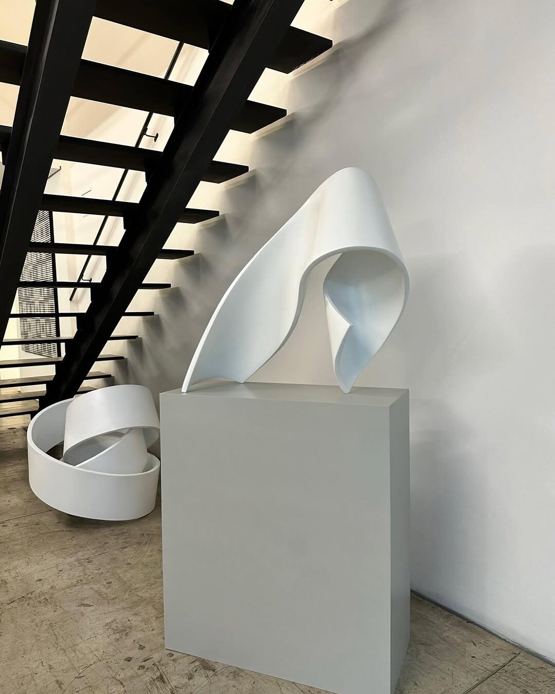 Escultura branca de Tomie Ohtake sob escada metálica